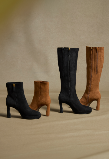Four knee-high and ankle boots in black and tan suede, arranged in pairs of different heights on a beige fabric backdrop.