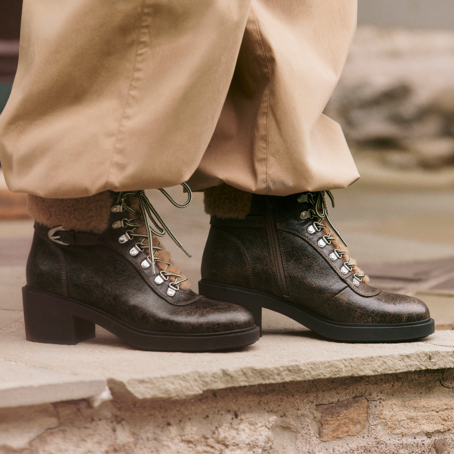 cropped image of lace up heeled boots with laces and shearling trim